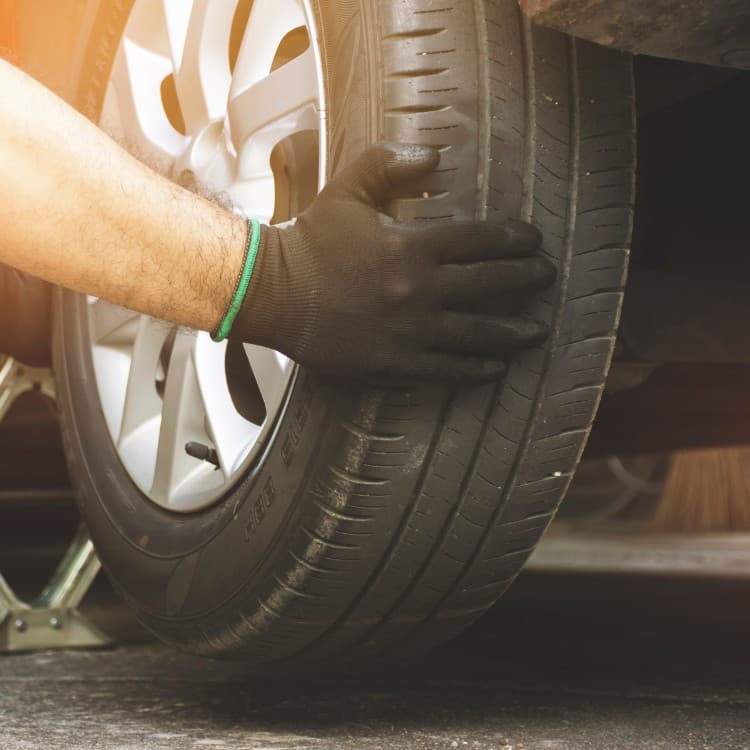 Technician checking a tire's tread and sidewall